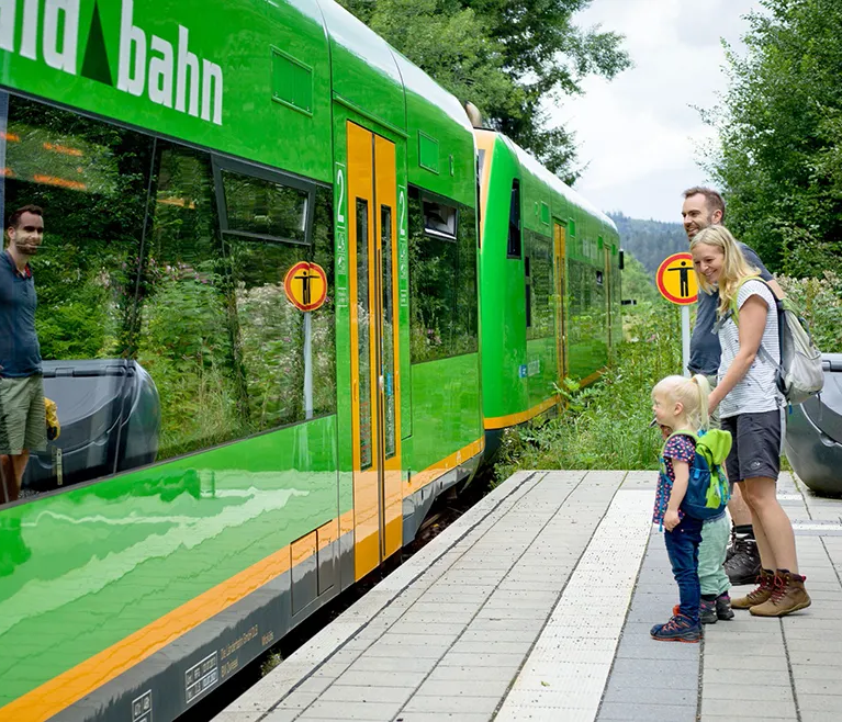 Familie steigt in Waldbahn ein