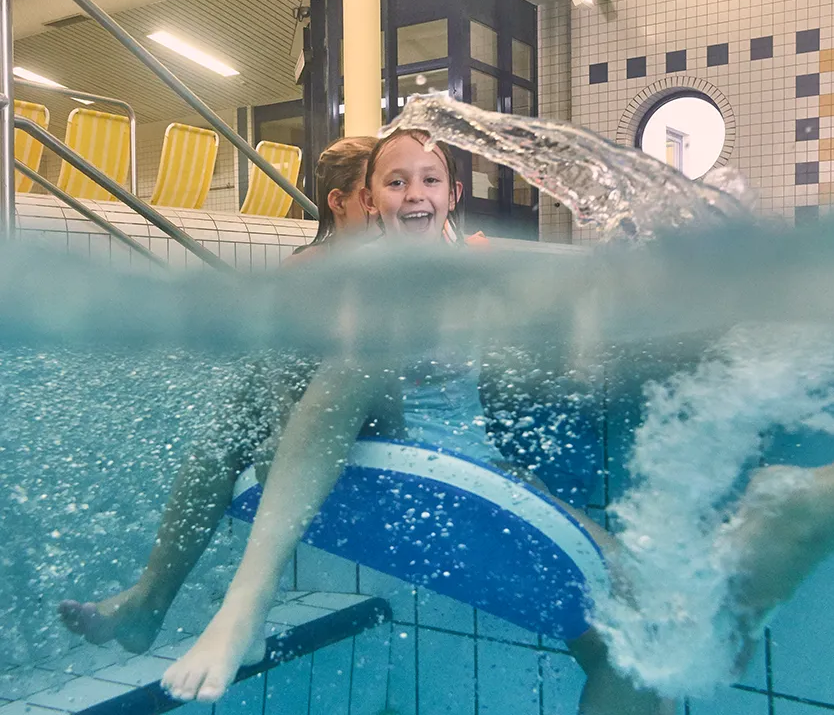 Kinder plantschen im Schwimmbecken