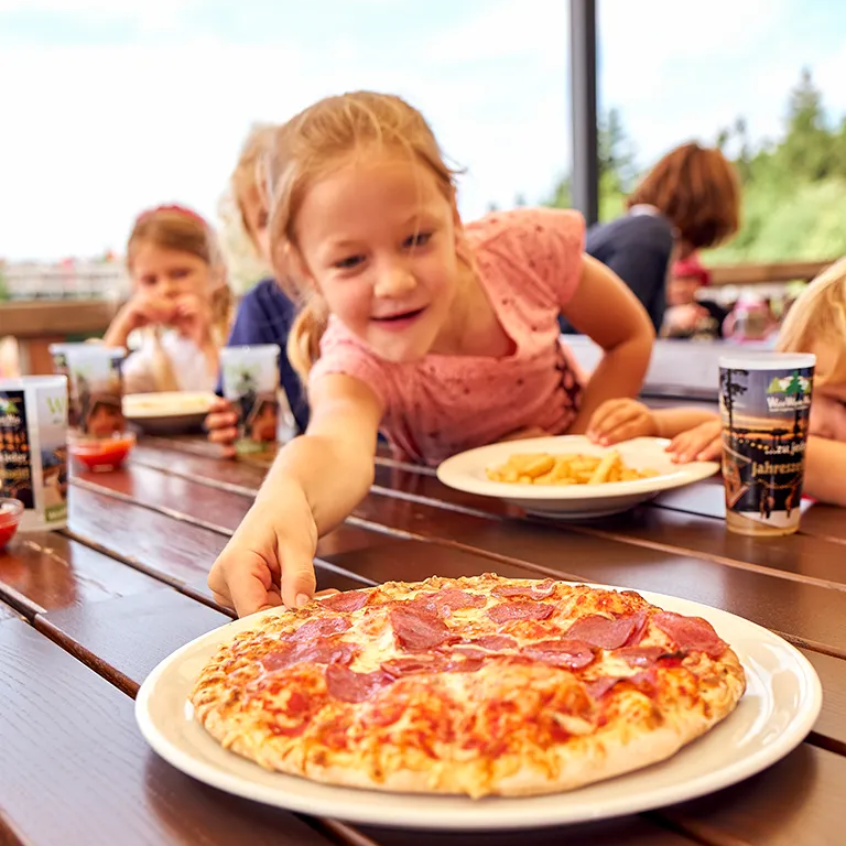 Kind greift nach Pizza