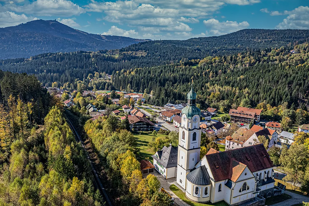 Blick auf Bayerisch Eisenstein, im Vordergrund die Kirche, im Hintergrund das Arberareal