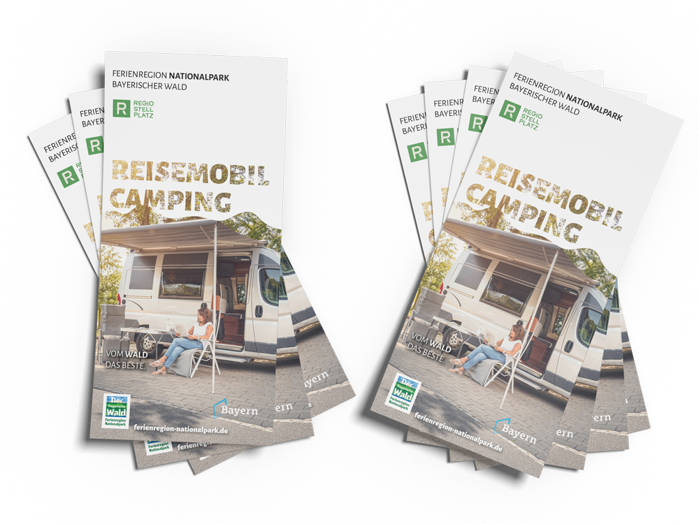 Zwei Stapel von Broschüren über Reisemobil-Camping im Bayerischen Wald, mit einer Frau, die entspannt auf einem Stuhl sitzt.