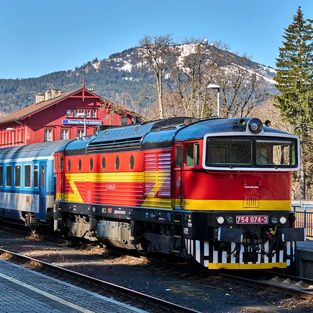 Zug der tschechischen Bahn An einem sonnigen steht der farbenfrohe Zug der tschechischen Bahn am Grenzbahnhof, dahinter der markante Große Arber im Blickfeld..