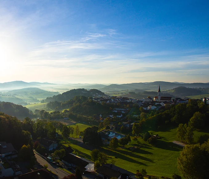 Ein weites Panorama rund um Schönberg, das in der diesigen Morgenbeleuchtung erstrahlt mit blauem Himmel.