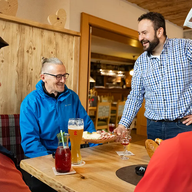 Die entspannte Atmosphäre zeigt Radfahrer, die nach einer Tour in einem Restaurant eine Mahlzeit und Getränke genießen.