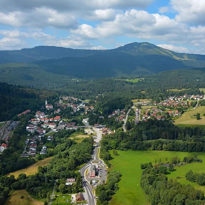 Panoramaansicht Bayerisch Eisenstein mit dem Großen Arber im Hintergrund Ein Blick auf das wunderschön in die Grenzregion eingebettete Bayerisch Eisenstein, mit dem Grenzbahnhof in Sicht, dem Großen Arber im Hintergrund und Wolken am Himmel.