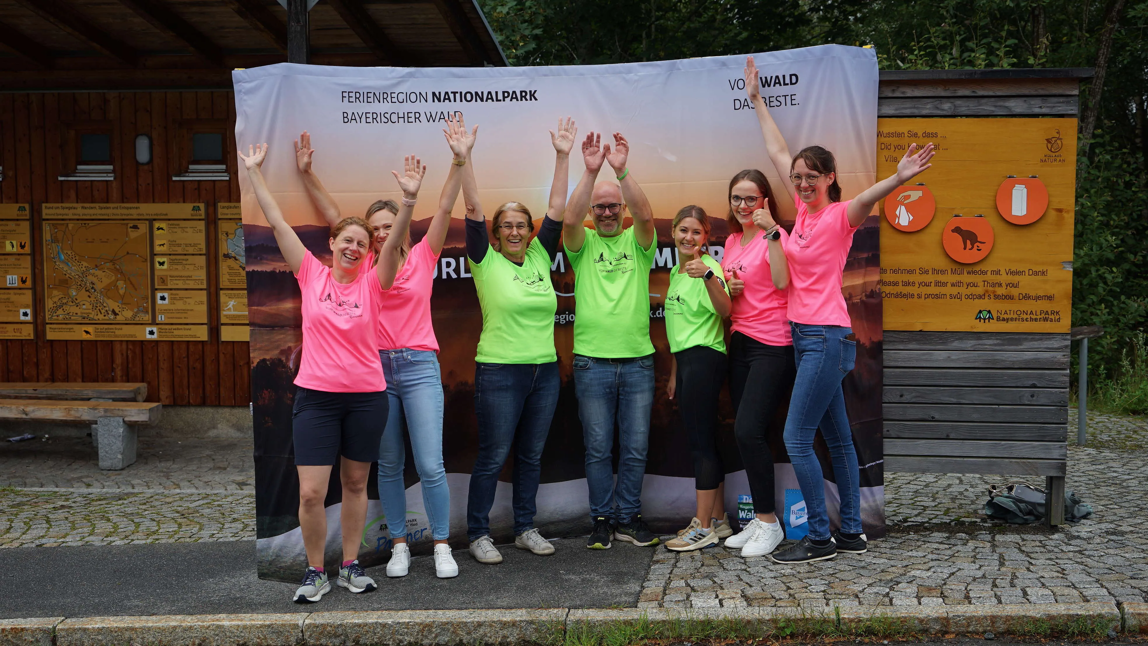 Mitarbeiter der Ferienregion stehen vor einem Banner, strecken die Arme in die Luft und freuen sich Mitarbeiter der Ferienregion stehen vor einem Banner, strecken die Arme in die Luft und freuen sich