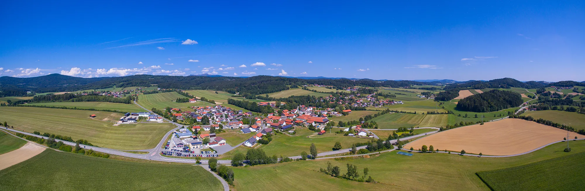 Panoramablick auf Eppenschlag mit den sanften Hügeln des Mittelgebirges unter kräftig blauem Himmel Eine weite Landschaft eröffnet sich rund um Eppenschlag, einem kleinen Dorf unter strahlend blauem Himmel, der die Idylle unterstreicht.